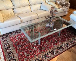 A view of the living room featuring leather sofa, Persian rug, and Coffee Table