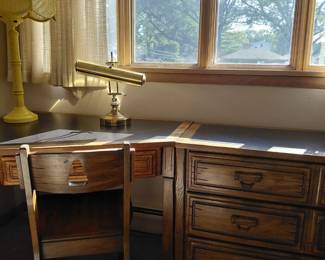 Corner desk with brass lamp and chair