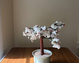 Beautiful decorative bonsai tree featuring delicate white blossoms with red accents, sculpted branches, and a pale celadon-style ceramic planter. The detailed floral design gives it a graceful, elegant look with strong Asian-inspired character.  A lovely estate find for a tabletop, shelf, console, or decorative display.