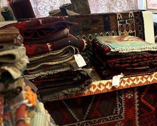 Warehouse stacks filled with one of a kind rugs ready to explore.