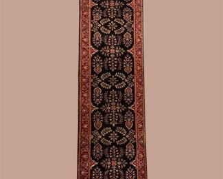 Narrow dark blue runner featuring repeating geometric medallions and subtle rust and ivory detailing.