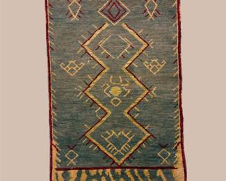 Teal and muted green geometric rug featuring bold angular diamond motifs with warm gold and rust accents.