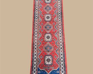 Red runner featuring repeating blue and ivory medallions with a detailed geometric border.