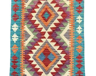 Vibrant geometric rug featuring large diamond motifs in turquoise, red, orange, yellow, ivory, and burgundy.