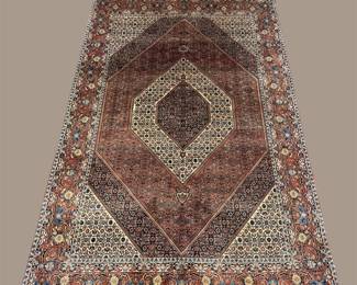 Soft mauve, ivory, burgundy, and muted blue traditional rug featuring layered diamond-shaped medallions and an intricate border.