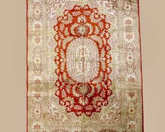 Ivory rug featuring a dramatic red central medallion with delicate surrounding botanical motifs.