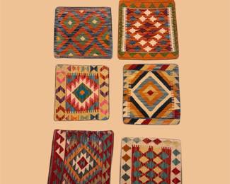 Colorful collection of small geometric woven rugs featuring diamond, checkerboard, and tribal-inspired patterns.