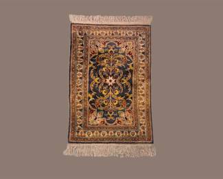 Small traditional rug featuring rich gold, navy, and rust floral motifs with a decorative border.
