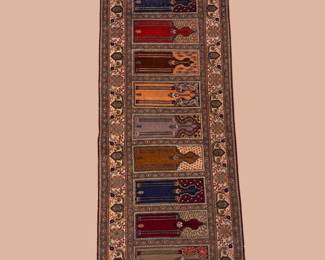 Long ivory runner featuring colorful geometric panels in rust, navy, red, gold, and brown surrounded by a detailed border.