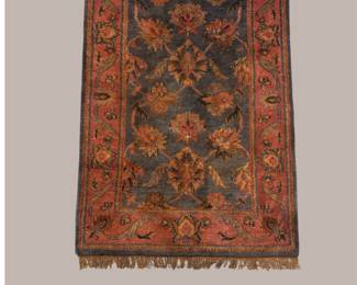 Warm rust and orange traditional rug featuring large floral motifs with muted green, blue, and gold accents.