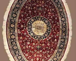 Deep red oval-style medallion rug featuring an elaborate central design surrounded by intricate ivory, navy, and gold detailing.