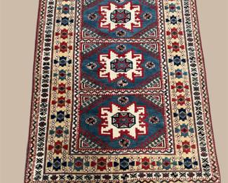 Dark blue rug featuring bold ivory geometric motifs and repeating decorative medallions.