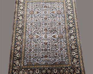 Dark navy, ivory, and gold traditional rug featuring a dense all-over floral design and an intricately patterned border.