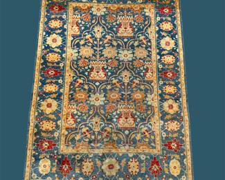 Deep blue and gold traditional rug featuring repeating floral motifs and an ornate decorative border.