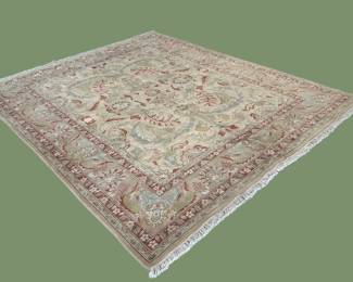 Pale green and ivory rug featuring a softly faded traditional pattern and an understated distressed appearance.