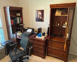 Office chair. Shredder. Desk with drawers and shelves and display case. Electric typewriter. Printer. Desk lamp. 