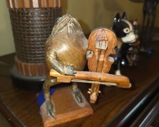 vintage anthropomorphic taxidermy or folk art sculpture of a toad or frog playing a stringed instrument (such as a violin, cello, or bass) mounted on a small wooden base