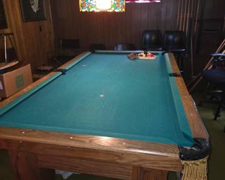 wooden-frame slate pool table, closely resembling a vintage Brunswick Santa Fe (manufactured around the late 1980s) or similar oak-trimmed model with green felt and ornate leather-fringed drop pockets