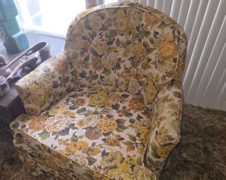 Vintage floral-print armchair in yellow, gold, and olive tones, typical of mid-century to 1970s interior style.