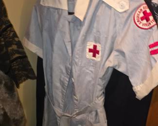 authentic vintage 1940s American Red Cross volunteer uniform dress in a blue and white pinstripe cotton fabric with an embroidered Red Cross emblem on the pocket and a sleeve patch