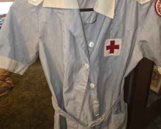 authentic vintage 1940s American Red Cross volunteer uniform dress in a blue and white pinstripe cotton fabric with an embroidered Red Cross emblem on the pocket and a sleeve patch
