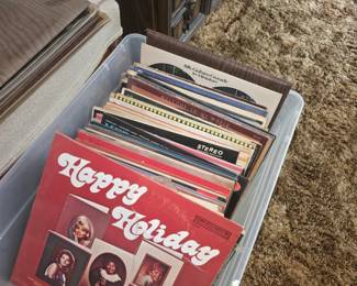 front vinyl record in the plastic storage bin appears to be the 1974 compilation LP Happy Holiday released on Columbia Special Products (catalog number P 12438), featuring holiday performances by artists such as Debbie Reynolds, Patti Page, Doris Day, Anita Bryant, and Mahalia Jackson.