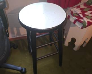 vintage or rustic black-painted wooden round-top stool with a white speckled or enamel-style seat and multi-tiered wooden stretchers