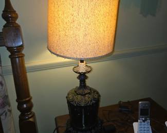 Vintage cast iron or metal-ornament table lamp with an ornate, embossed canister-style base and a converted candle-style or oil/photogen lamp fixture