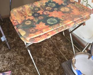 image shows vintage mid-century modern folding metal TV tray tables with a retro orange and yellow floral "flower power" pattern.