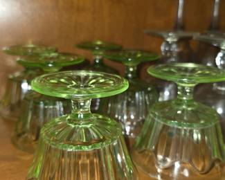 vintage green depression glass sherbet bowls or ice cream dishes, which are commonly made of uranium glass and feature a fluted or ribbon pattern (such as those produced by Hazel-Atlas in the 1920s–1930s)