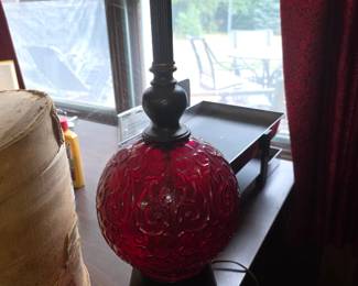 ruby red glass globe table lamp, often styled in the Hollywood Regency or mid-century aesthetic featuring an embossed floral or scroll pattern