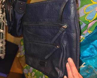 navy blue Rosetti Aria Crossbody Bag featuring a textured faux-leather exterior and multiple front zipper compartments.