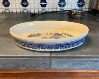 Blue Willow Oval Serving Platter — Large oval ceramic serving platter decorated with classic blue willow transferware motifs. The white body with deep blue border and central willow scene is a recognizable pattern that works well as a serving piece or display. Glaze is intact with only light surface wear visible in photos and no obvious chips or cracks. Measures a generous size suitable for roasts or as a centerpiece serving dish.