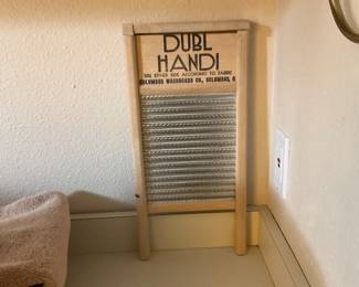 DUBL HANDI Washboard — DUBL HANDI wooden washboard with metal ribbed scrubbing surface and simple frame, labeled "DUBL HANDI" and "Columbus Washboard Co., Columbus, O." on the top board. Solid pine frame with galvanized ribbed face shows light surface wear and a few small dings consistent with age but overall sound and sturdy. Measures compactly for display or practical use in laundry décor or as a prop; good for collectors of household relics or rustic home accents.
