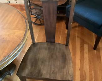 Solid Wood Dining Chair — Solid wood dining chair with a tall slat back and contoured seat offering classic, simple styling. The chair appears to be stained a medium brown with visible wood grain and sturdy square legs, suitable for use at a dining table or as an extra seating piece. Estimated overall size is compact and easy to move, making it practical for smaller dining spaces or as supplemental seating. Condition is good with light surface wear to the seat and minor scuffs on edges consistent with normal use.
