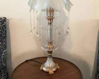 Art Glass Crystal Tassel Lamp — Decorative table lamp with a frosted ruffled glass shade and hanging crystal tassels surrounding a fluted column and gilded base. The piece combines glass drops and long glass rods to create a chandelier-like effect on a small lamp suited for a side table or bedside; the base shows painted gold accents and classic fluting. Appears to be vintage-inspired with light surface wear to the base and minor dust on the glass elements, cord intact (working condition untested). Measures compactly for small-table use and makes an elegant accent lighting piece.