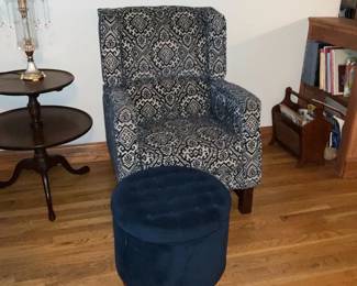 Blue Patterned Accent Armchair — Comfortable upholstered accent armchair in a navy-and-ivory geometric/medallion pattern with squared arms and a slightly winged back. Solid wood block legs and a medium-firm seat make it suitable for a reading corner or living room; included in photos is a separate round tufted navy ottoman (seen in images) but ottoman not guaranteed included. Fabric shows light, even wear consistent with normal use and no visible tears or stains from photos. Measures compactly for small spaces and pairs well with traditional or transitional decor.