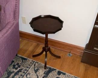 Octagonal Mahogany Tilt-Top Pedestal Tab — Small octagonal pedestal side table in a dark mahogany finish with a scalloped gallery edge and tripod base. The turned central column and curved tripod legs suggest traditional styling; top shows light surface wear and small scuffs consistent with normal use. Sturdy overall but sold as cosmetically used furniture for living-room or entry use. Compact footprint makes it easy to move for display or lamp/tabletop use.