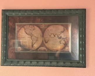 Framed Double Hemisphere World Map — Decorative framed double-hemisphere world map print with a deep carved dark-green frame and mauve/burgundy mat. The piece presents an antique-style map reproduction showing both Western and Eastern hemispheres; frame shows carved leaf motif and small scuffs visible along edges. Glass front appears intact and overall condition is good with light wear from display; suitable wall art for study or living room. Overall dimensions estimated to fit a standard large wall frame and the piece is ready to hang with the included top hook.