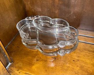 Clear Glass Divided Serving Dish — Clear glass divided serving dish with scalloped cloud-like shape ideal for nuts, condiments, or small snacks. Made of molded clear glass with three connected compartments and rounded knop accents on the rim. Measures approximately 1.5 inches high, 9 inches wide, and 6 inches deep; lightweight and easy to display or store. In good condition with no visible chips or cracks but shows light surface scratches from normal use.