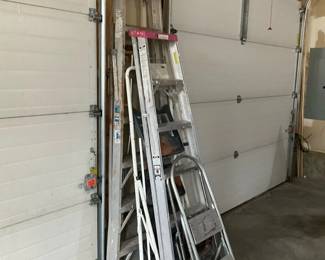Mixed Aluminum Step & Extension Ladders — Group of assorted ladders including an aluminum extension ladder, aluminum step ladder, and smaller folding step stools suited for garage or home use. Primarily constructed of lightweight aluminum with rubber feet and a few painted wooden sections visible; no brand clearly readable in photos. Overall useful set for DIY, painting, and light trades work; largest extension ladder appears approximately 12 ft when extended and the tallest step ladder about 6 ft folded. Ladders show normal wear with scuffs, paint splatters, and surface oxidation but appear structurally sound — recommend testing locks/hardware before heavy use.