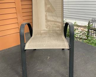 Outdoor Sling Patio Chair — Comfortable outdoor sling patio chair with curved aluminum frame and breathable mesh seat/back. The neutral tan mesh is supported by a dark powder-coated metal frame with integrated armrests, suitable for porch or patio seating. Estimated overall footprint is typical of dining/occasional patio chairs and it's lightweight for easy moving. Shows outdoor wear and light soiling on the mesh with minor scuffs to the frame but no structural damage.