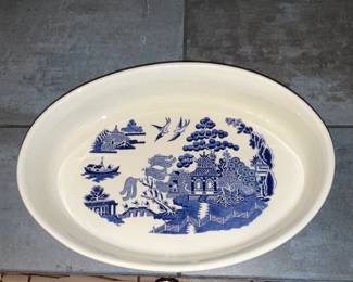Blue Willow Oval Serving Platter — Large oval ceramic serving platter decorated with classic blue willow transferware motifs. The white body with deep blue border and central willow scene is a recognizable pattern that works well as a serving piece or display. Glaze is intact with only light surface wear visible in photos and no obvious chips or cracks. Measures a generous size suitable for roasts or as a centerpiece serving dish.