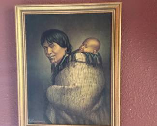 W. Lindauer Portrait Print — Framed portrait print signed lower left by W. Lindauer depicting a woman carrying an infant in traditional wrap; the image is vertically oriented and set in a gold-tone rabbeted wood frame with inner black liner. The print shows even color with light surface age and the frame has small chips and wear consistent with display use. A tasteful decorative piece for wall display; overall structurally sound but sold as a framed print rather than an original painting. Measurements listed are approximate overall framed dimensions.