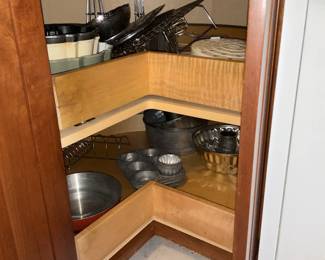 Mixed Kitchenware Lot — A large lot of everyday kitchenware including nested stainless mixing bowls, metal cake pans and molds, colanders, a few nonstick frying pans, glass lids, assorted baking tins, plastic storage lids, and small appliances/attachments (hand blender parts and food-processor bowl/blade shown). Pieces are mixed metals, glass and plastic with visible wear and light staining on some cookware; overall serviceable for home use or as backup pieces. No major brand markings visible in photos; items sold as-is and sold together as one lot. Estimated combined size and weight below reflect the full grouped contents.
