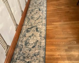 Blue Beige Hallway Runner Rug — Long hallway runner rug in a distressed blue and beige medallion pattern that fits narrow entryways or corridors. Low-pile synthetic construction with bound edges offers durable, easy-care performance and a contemporary, slightly faded look. Estimated at 8 feet long and 2 feet wide (see dimensions) which makes it ideal for a foyer, kitchen pass-through, or stair landing runner. Good used condition with light wear typical of floor use and no visible stains or tears.