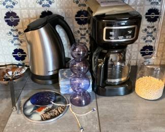 Black+Decker Electric Kettle — A stainless-steel Black+Decker electric kettle with black plastic handle and base, shown next to a black drip coffee maker. The kettle has a compact countertop footprint and a flip-top lid; the Black+Decker logo is visible at the base. Photos show light surface wear and normal countertop use but no obvious dents or cracks. Estimated overall size and weight make it easy to move and suitable for everyday kitchen use.