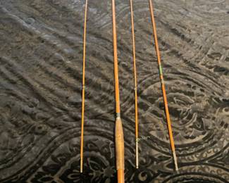 4-Piece Bamboo Fly Fishing Rod — Hard-to-miss four-piece bamboo fly rod with a wooden cork handle and metal ferrules; photos show all four sections laid out with original winding and guide wraps. The cane has a warm orange-brown finish and the handle shows honest wear and darkening from use consistent with age. No visible brand or model text is legible in the images, so this is best described as a classic bamboo split-cane style rod suitable for collectors or restoration; sections appear straight and guides intact. Condition is used with handle wear and minor finish scuffs but no obvious breaks in the rod sections.