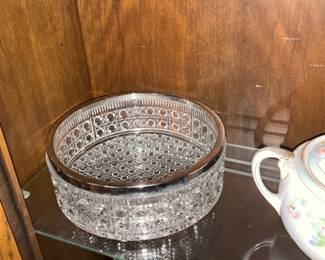 Cut Crystal Silver-Rim Bowl — Heavy cut crystal serving bowl with a polished silver-tone rim, offering a classic decorative and functional piece for display or serving. The bowl features intricate pressed/cut patterns around the sides and a hobnail-style base, giving strong sparkle and visual texture. Approximate overall size and weight make it suitable for a mantel, buffet or china cabinet display; see dimensions below for exact measurements. In good condition with light surface wear and a few small scuffs to the silver trim consistent with normal use; no visible chips or cracks in the crystal.