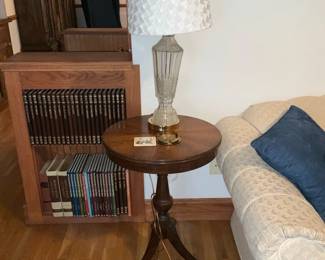 Mahogany Tripod Round Side Table — Solid mahogany round tripod side table with turned central column and three splayed legs, classic small accent table ideal for living room or entry. The top shows a warm patina and surface wear consistent with age; legs and column are sturdy though there are light scuffs and finish loss on the feet. Simple, traditional form that pairs well with period or transitional furnishings; measures compactly for a lamp or display. Good usable condition for resale with honest surface wear noted.